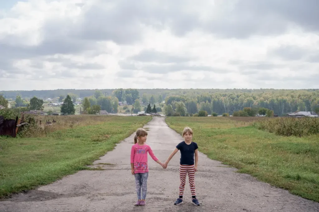 Даша и Вика Фельхле недалеко от своего дома в селе Корнилово. Центр поддержки семей и детей «Вместе» помог семье приобрести дрова на зиму, чтобы дети не оказались в приюте. Фото: Дмитрий Яцюк.
