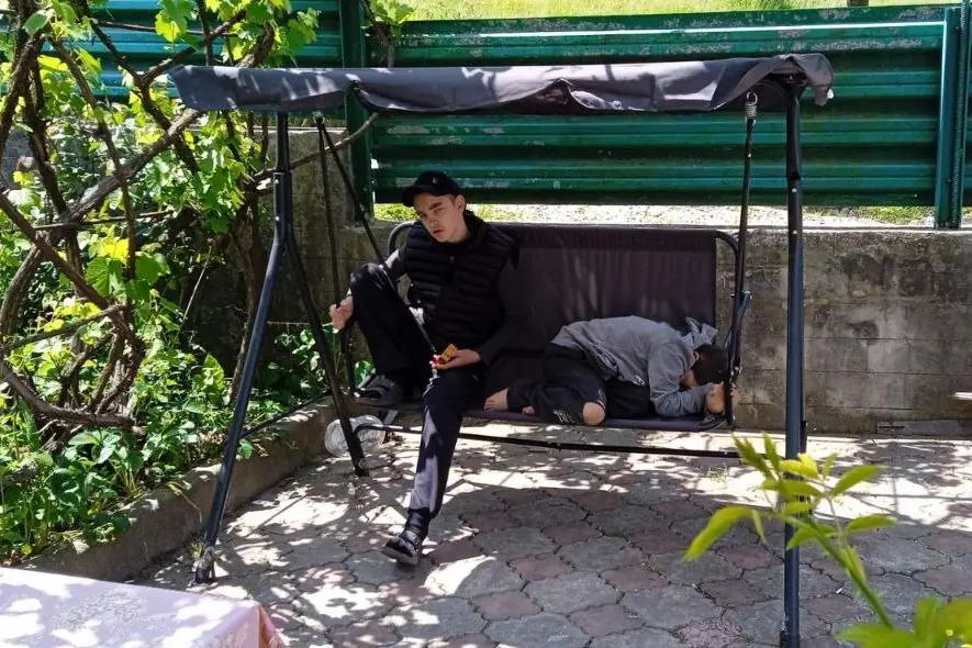 Сыновья Ольги Мазур Саша (слева) и Вова (дома) рядом с домом качаются на качели. Фото: личный архив.