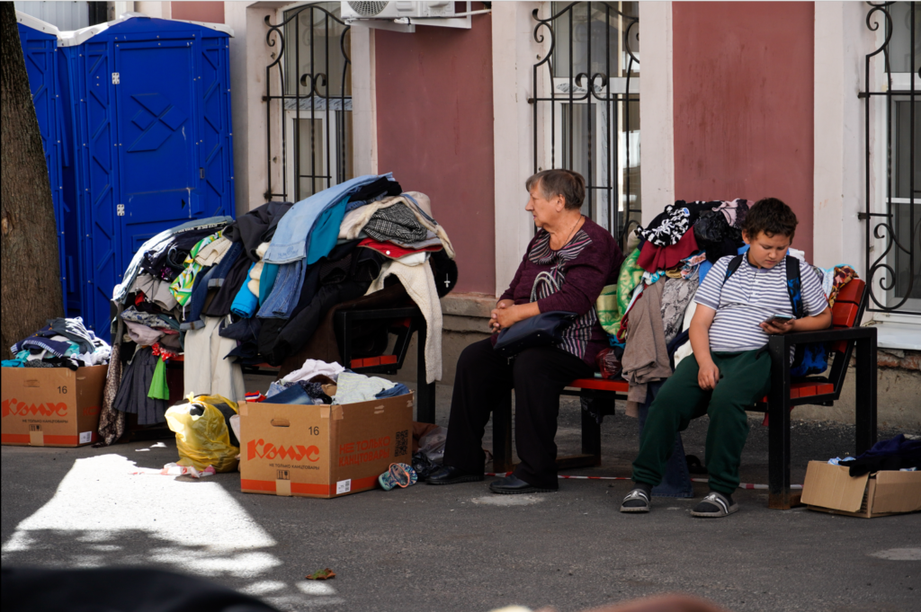 Семья беженцев из Курской области ожидает раздачу гуманитарной помощи.