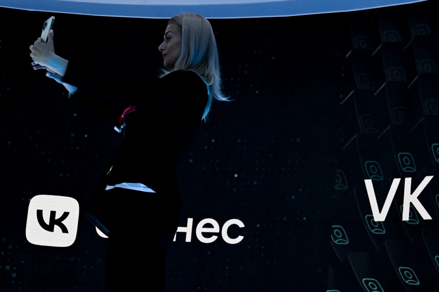 Участница ПМЭФ в Санкт-Петербурге на фоне сенда VK