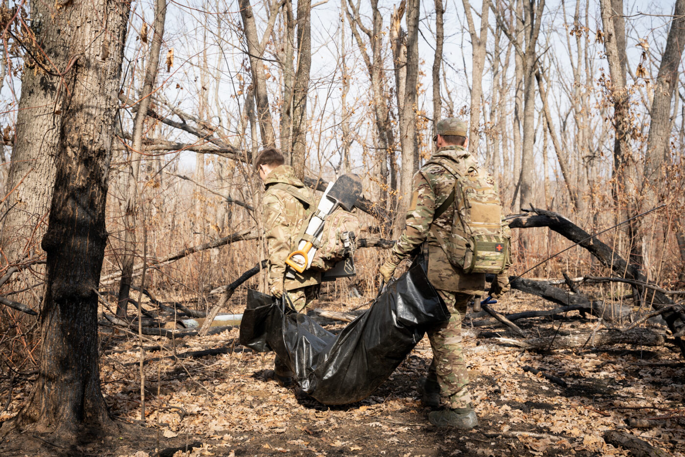 Волонтёры украинской организации «Плацдарм» несут останки погибшего российского солдата в Донецкой области, Украина, 11 марта 2025 года. Фото: Alfons Cabrera/NurPhoto/via Reuters Connect.
