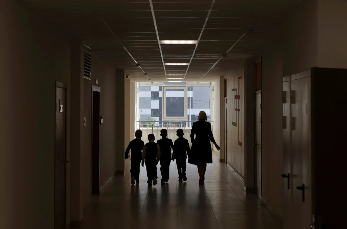 Учитель и ученики идут по коридору новой школы в День знаний в Санкт-Петербурге