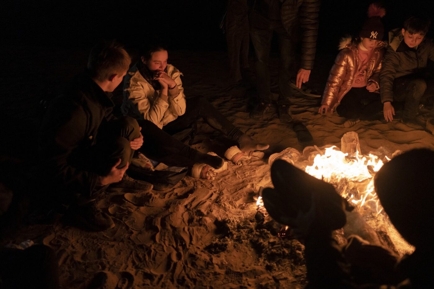 Российские просители убежища греются у небольшого костра на границе между США и Мексикой недалеко от Сомертона, штат Аризона