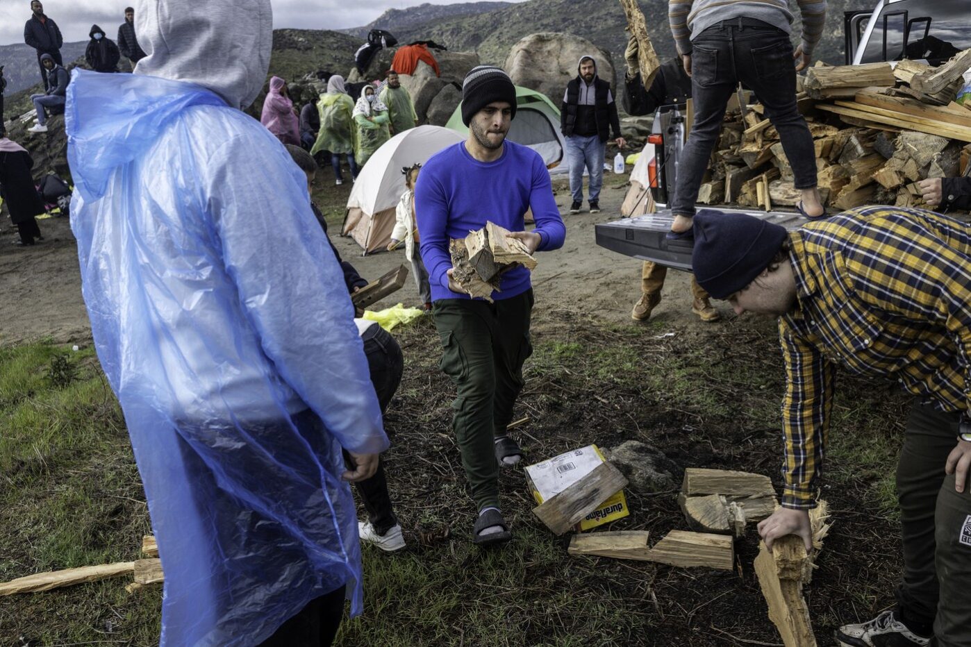 Российские иммигранты собирают дрова, доставленные волонтерами, ожидая перевозки пограничниками США в Кампо, Калифорния