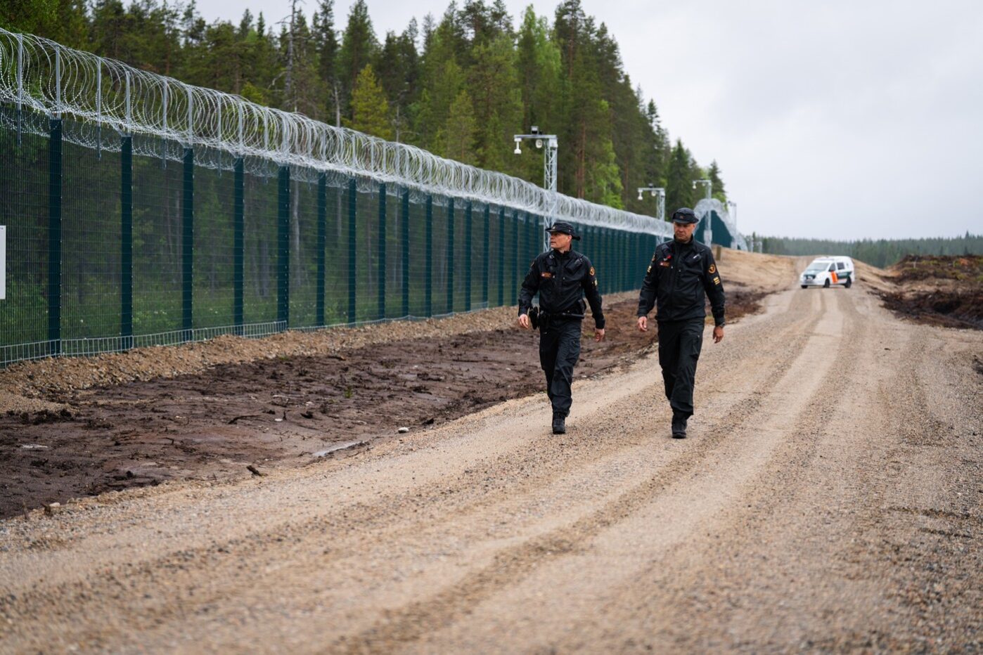 Пограничный переход Вартиус в Кухмо между Финляндией и Россией. Финские пограничники идут вдоль недавно возведенного забора длиной 200 км на границе с Россией