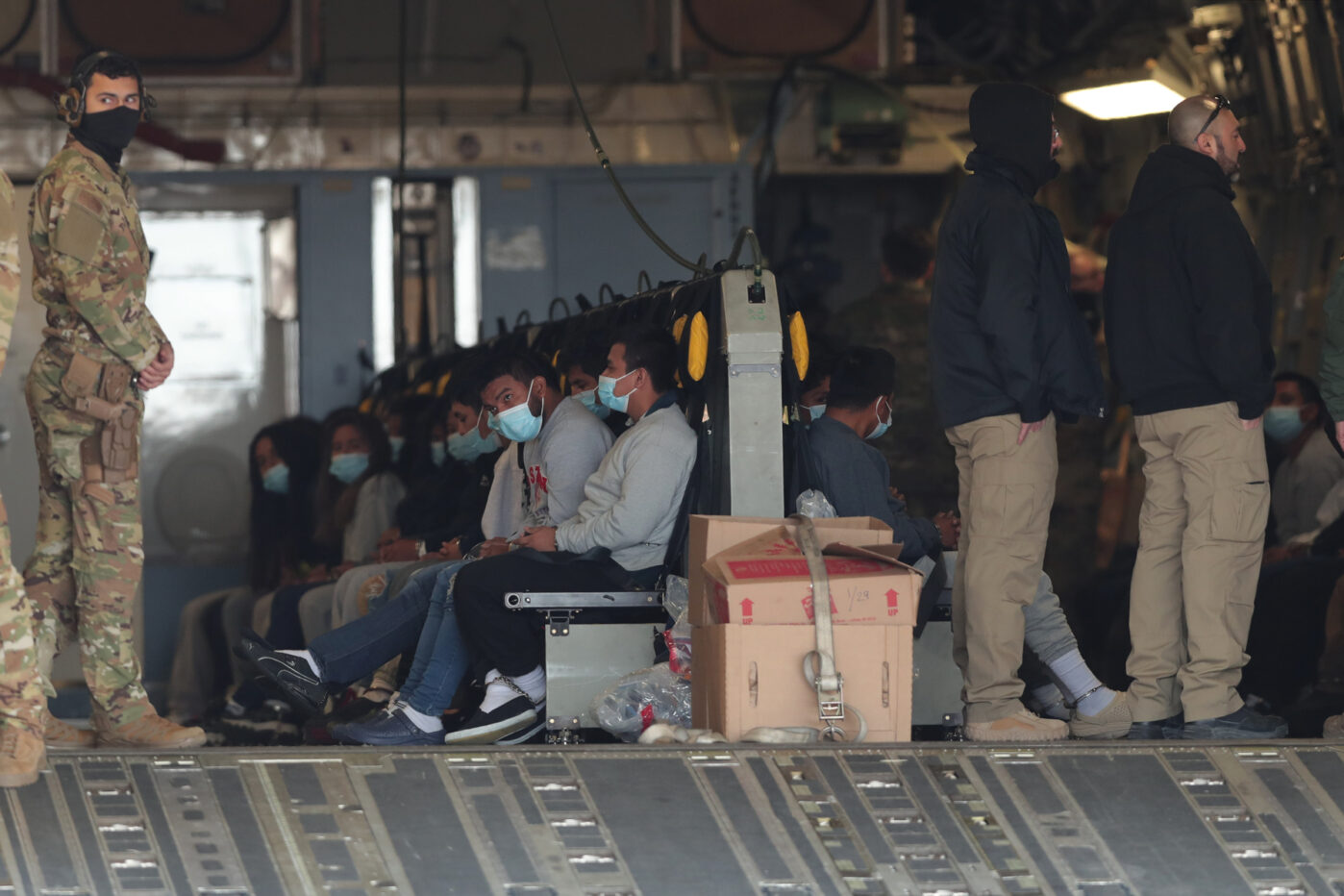 Депортированные из США мигранты ожидают вылета в американском военном самолете на базе в Эль-Пасо, штат Техас